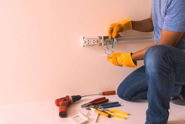 Electrician installing a new power outlet in a residential wall
